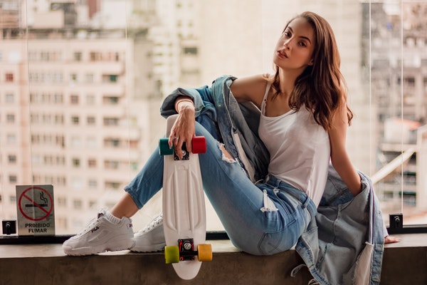photo-of-woman-in-denim-outfit-holding-penny-board-while-2437894