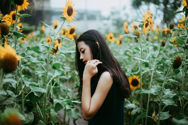 photo-of-woman-standing-near-sunflowers-3580811