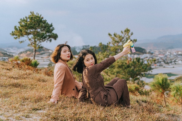 shallow-focus-photo-of-women-sitting-on-grass-3571364-1
