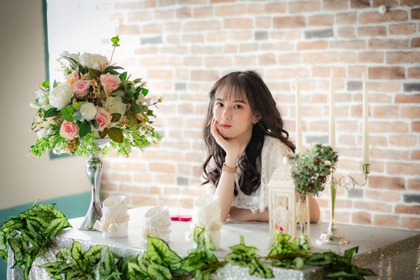 woman-in-white-sleeveless-dress-holding-bouquet-of-flowers-3690663