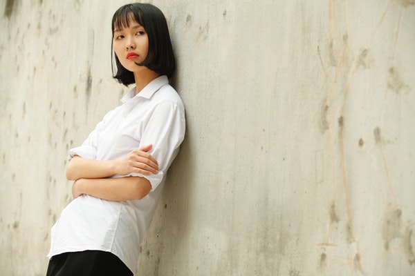 woman-leaning-on-concrete-wall-994316