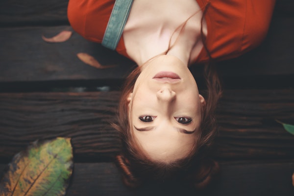 woman-lying-on-brown-wooden-surface-1895941