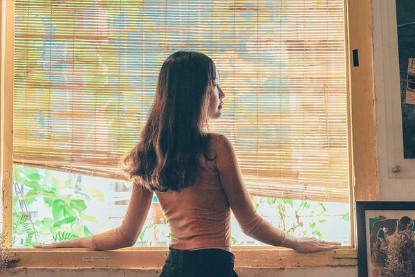 woman-standing-beside-window-1438502