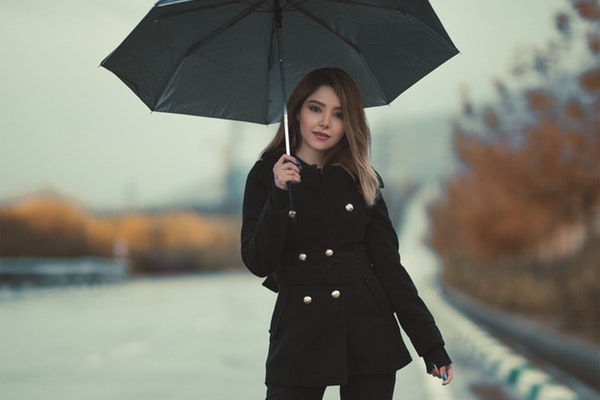 woman-standing-on-a-road-holding-an-umbrella-2887767-1
