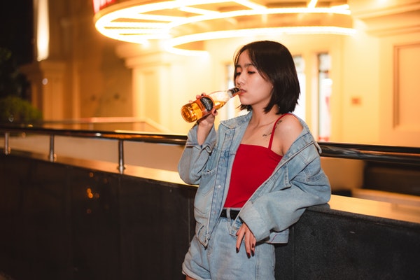 woman-wearing-blue-denim-jacket-while-drinking-beer-3653045-1